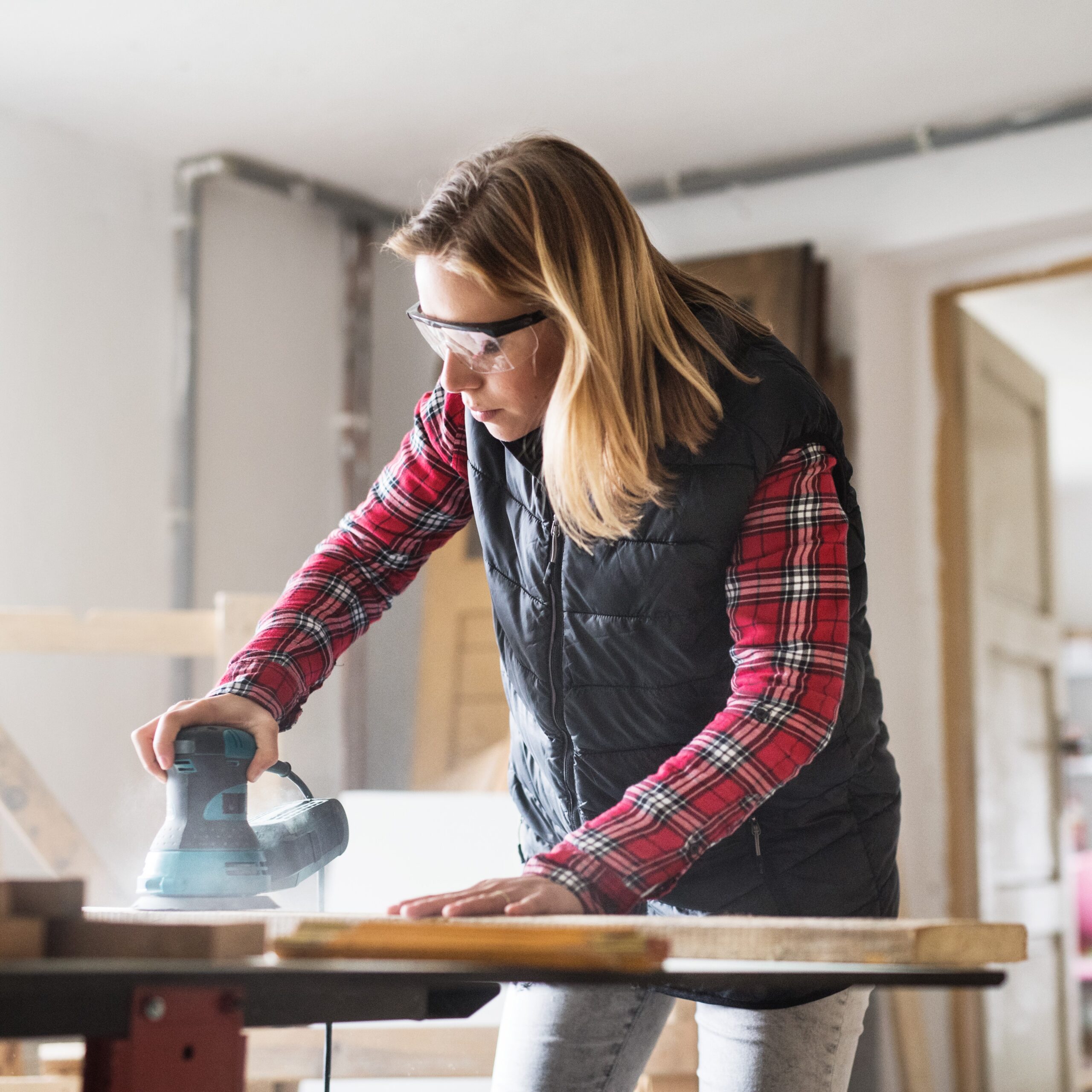 Young woman worker in the carpenter workroom.
